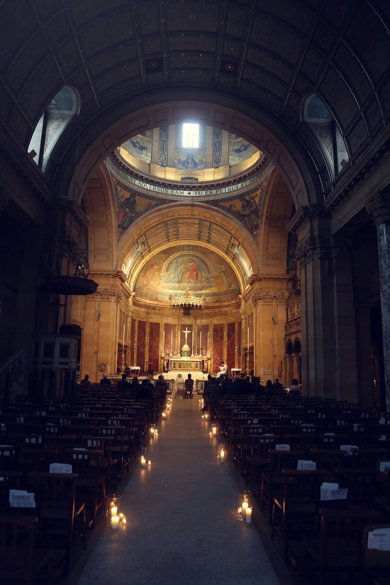 church decorated with glass cylinder candles down the aisles 