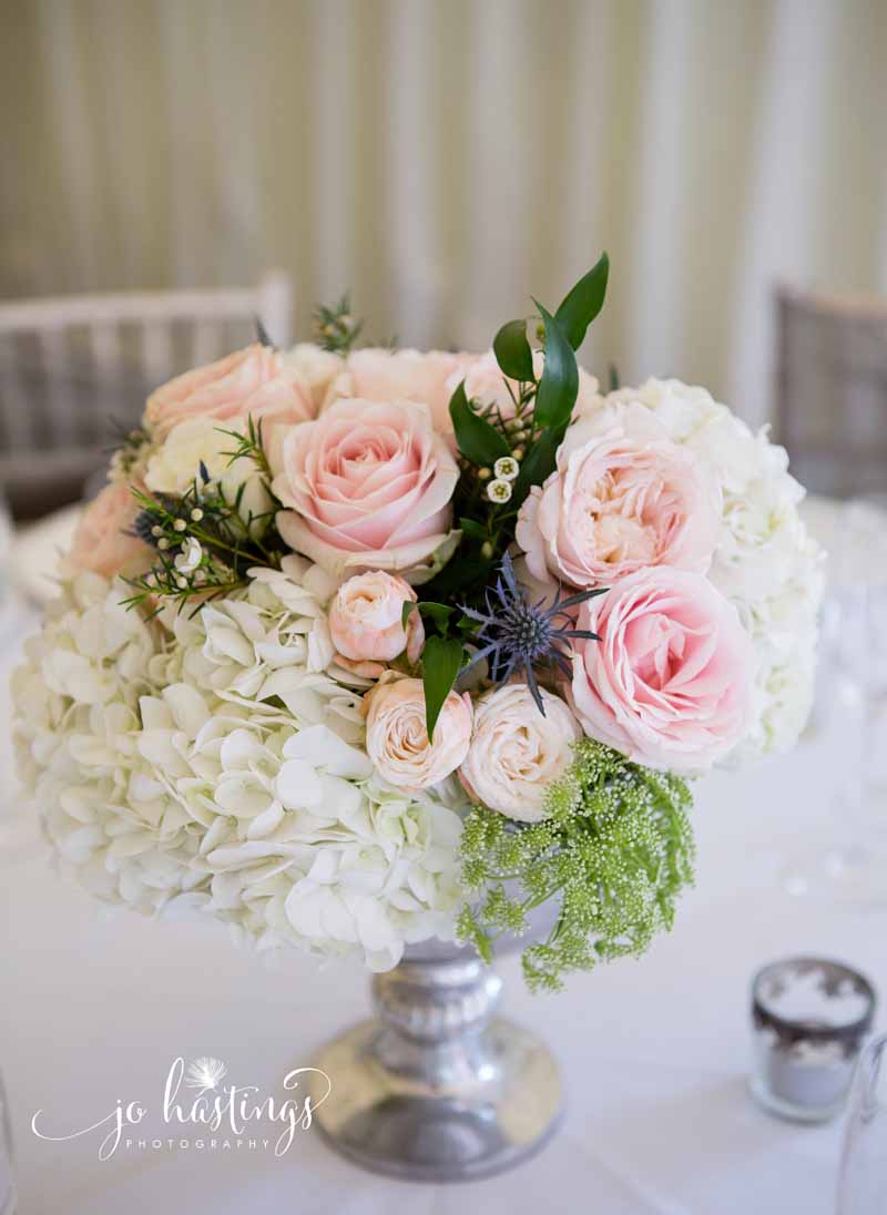 Blush pink roses and dusty blue thistles wedding centrepiece flowers low footed silver vases (2)