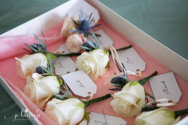 Cream rose button holes with dusty blue thistles by Passion for Flowers