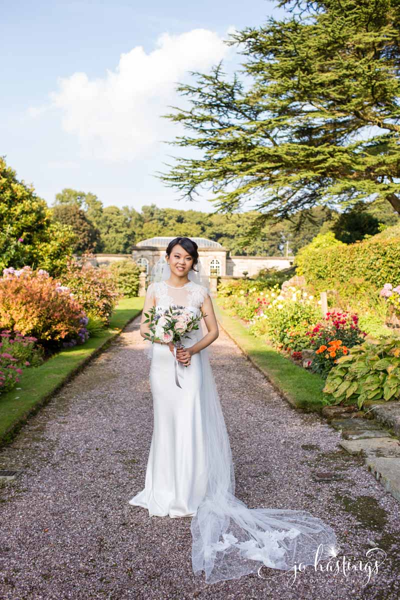 Wedding at Heath House bride in gardens with her bridal bouquet by Passion for Flowers