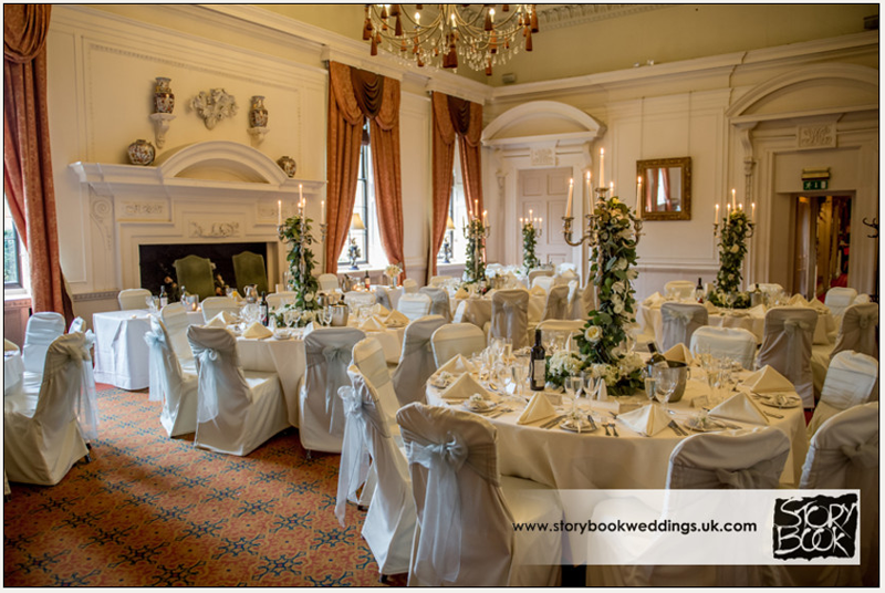 elegant candelabra centrepieces with white and green roses and foliage down the stem of candelabra by passion for flowers