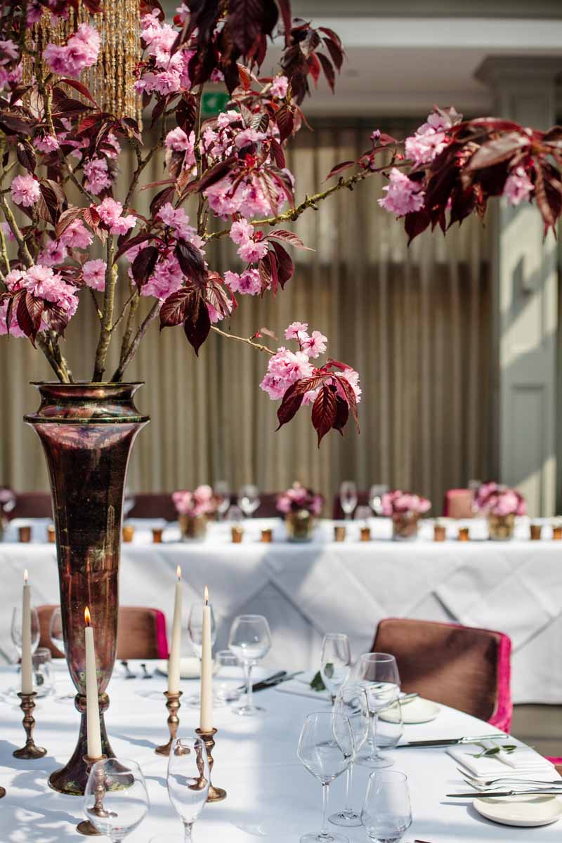 Tall centrepices bright pink blossom in bronze vases at Hampton Manor - flowers by Passion for Flowers @kmorganflowers