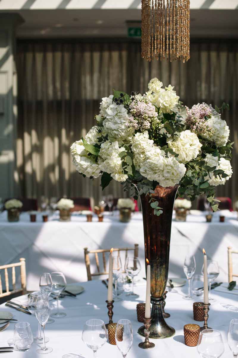 Tall wedding centrepiece bronze vases with classic white flowers at Hampton Manor Wedding - flowers by Passion for Flowers @kmorganflowers 