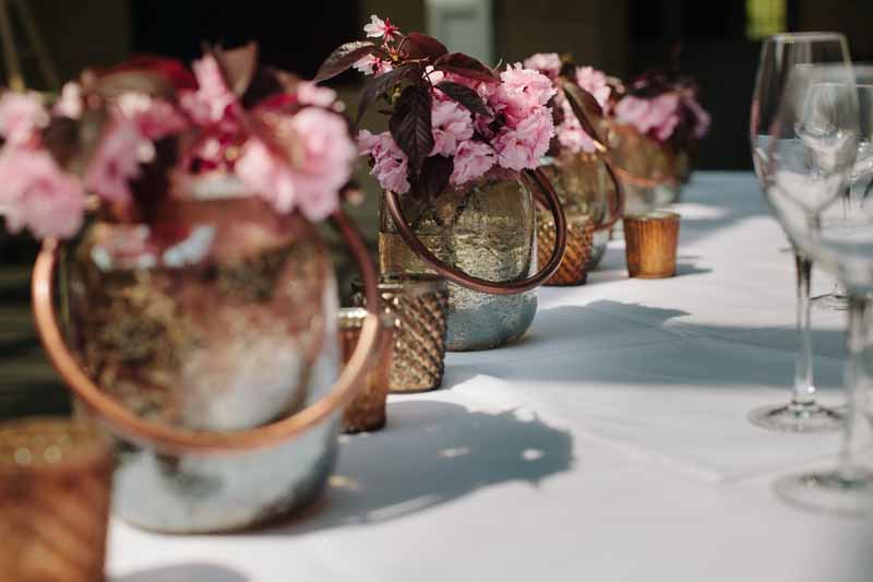 Top table wedding flowers bright pink blossom in bronze low vases and votives at Hampton Manor by Passion for Flowers @kmorganflowers 