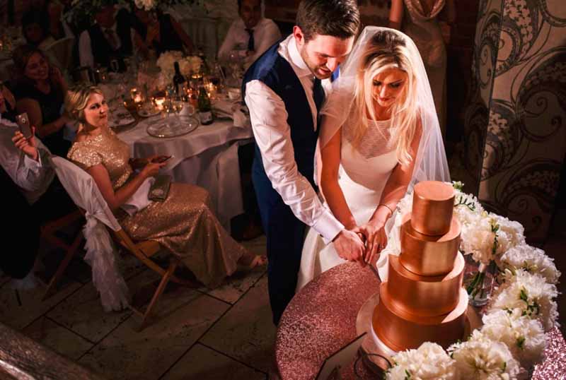 gold wedding cake with bouquets as cake table decorations