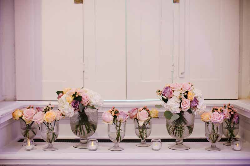glass-footed-bowls-of-pink-purple-peach-roses-for-wedding-centrepieces-compton-verney-2