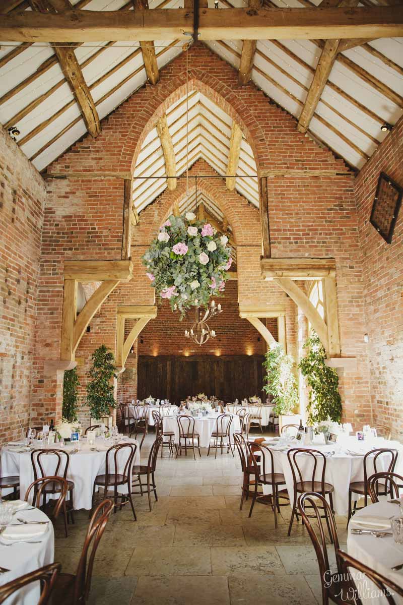 Large-hanging-flower-globes-in-barn-wedding-venue-by-Passion-for-Flowers