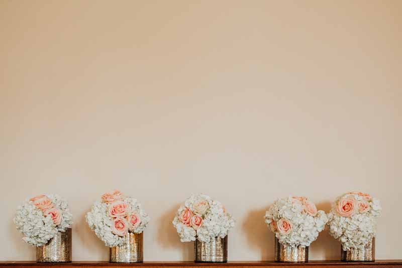 luxe-gold-vases-wedding-centrepieces-of-white-hydrangeas-peach-roses-gold-and-peach-wedding