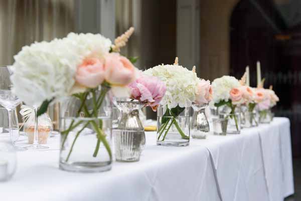 summer-wedding-top-table-flowers-in-glass-vases-pink-and-peach-wedding