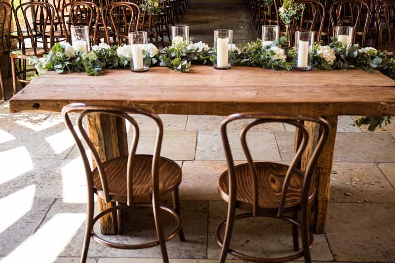 wedding-ceremony-table-foliage-eucalyptus-runner-with-glass-candles-lanterns