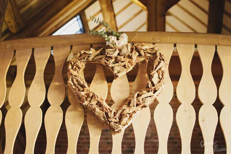 Wooden-heart-decorated-with-flowers-on-balcony-at-Shustoke-Farm-Barns