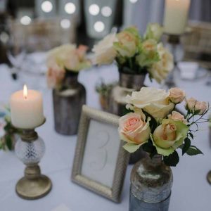Bronze bottles with peach pink roses wedding flowers at Hampton Manor - Passion for Flowers