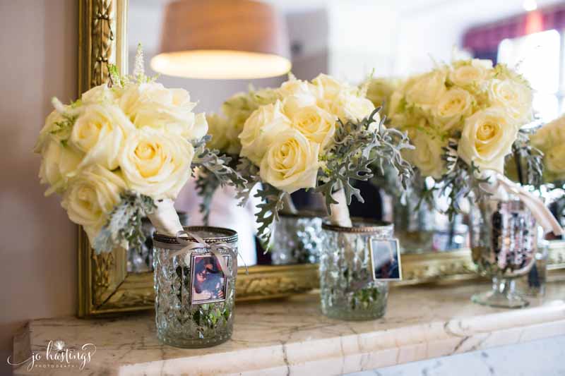 Cream rose bouquets with dusty miller in crystal vases with bridesmaids photos