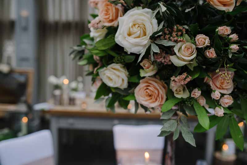 Peach cream roses with foliage wedding centrepieces