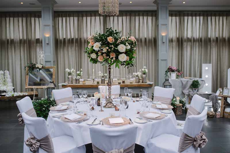 Tall bronze centrepieces wedding flowers at Hampton Manor by Passion for Flowers - peach cream foliage (2)