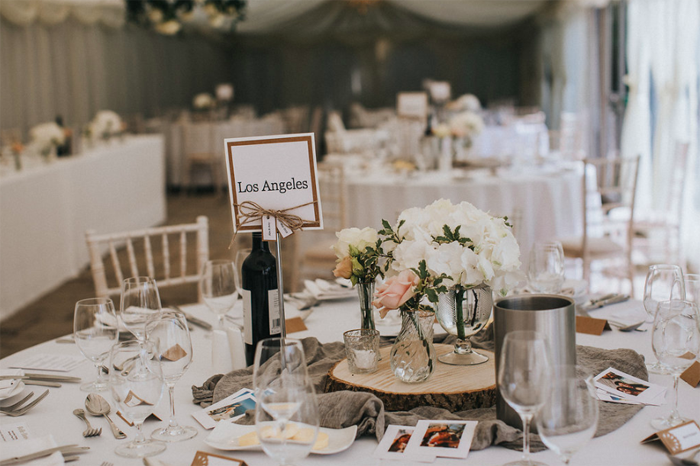 Rustic elegant centrepieces tree stumps with gass vases and grey runner Birtsmorton Court Marquee wedding
