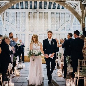 Barn wedding ceremony lots of candles lanterns - wedding florist Passion for Flowers