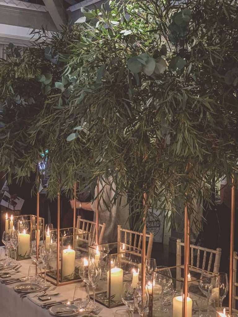 Gold floral stands of foliage above bronze nrass lanterns long wedding table styling Passion for Flowers Hampton Manor wedding florist