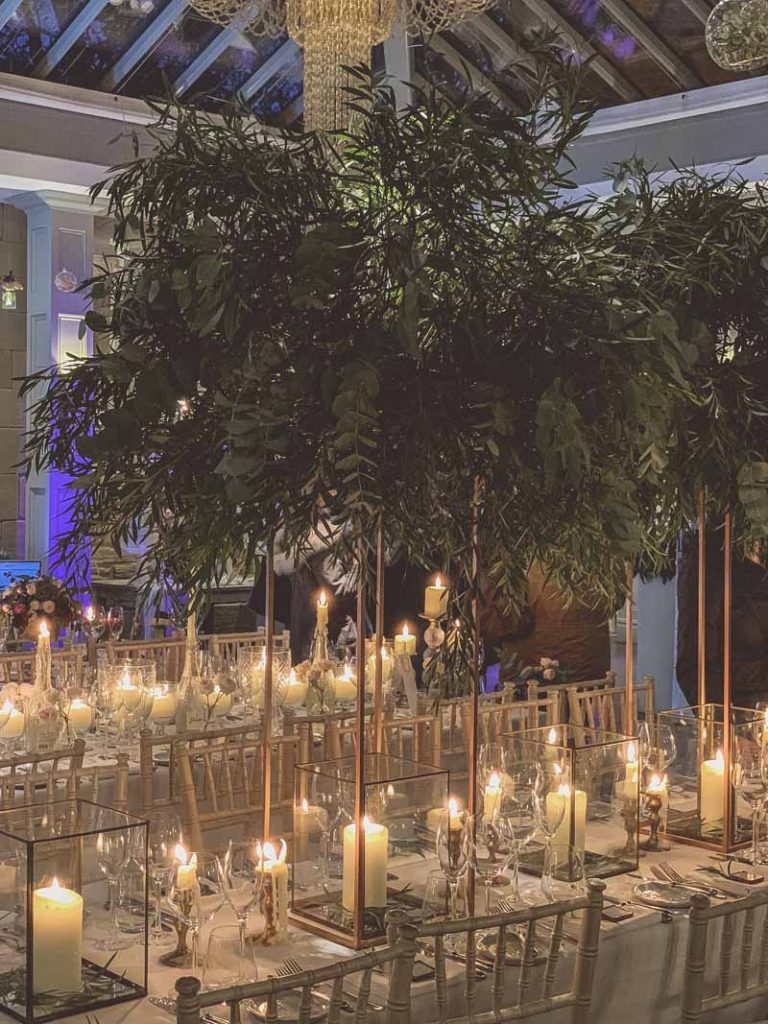 Gold floral stands of foliage above bronze nrass lanterns long wedding table styling Passion for Flowers Hampton Manor wedding florists