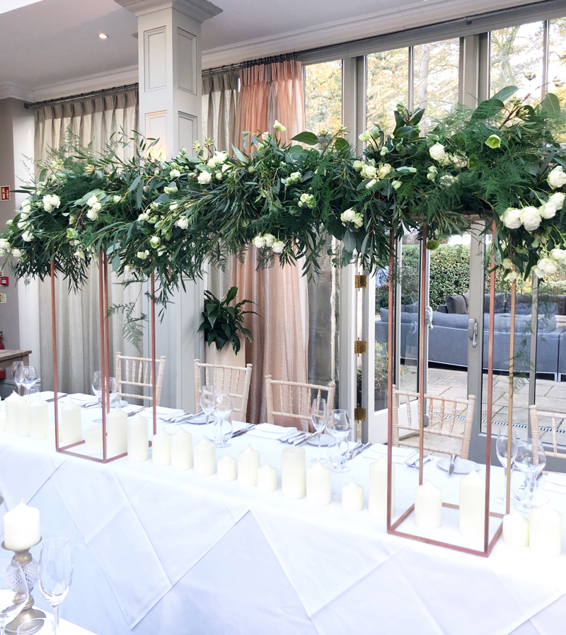 suspended flowers over gold floral frames top table hampton manor