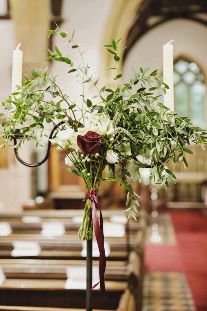 Winter wedding pew end alternatives bunch of roses foliage on candlesticks Passion for Flowers Birtsmorton Court