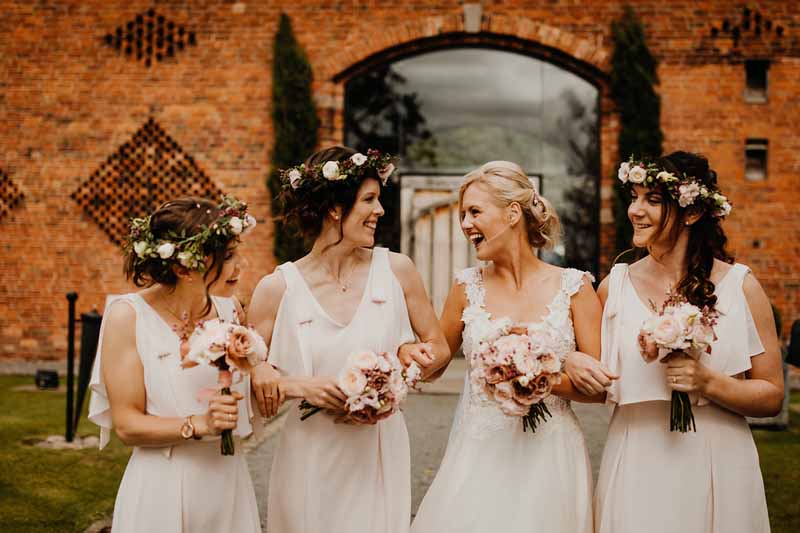 Bridesmaids cream dresses blush pink rose bouquets and flower crowns